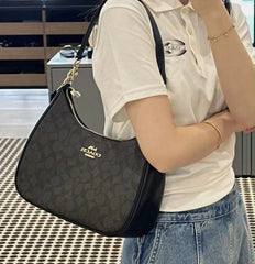 the Coach Teri Hobo in Signature Canvas, featuring a dark charcoal-and-black