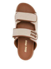 Miu Miu canvas logo slide sandals featuring a neutral ecru fabric upper with brown leather